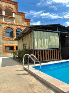 a house with a swimming pool next to a building at RedRose guest house Dilijan in Dilijan