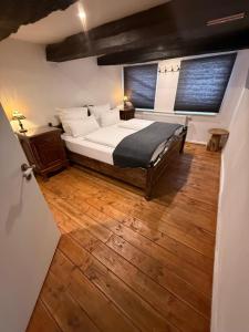 a bedroom with a bed and a wooden floor at Villa Dornröschen Hofgeismar in Hofgeismar