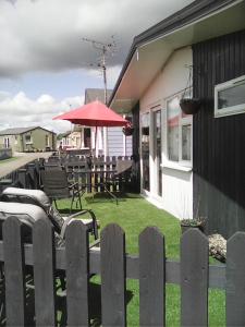 a backyard with a fence and chairs and an umbrella at yeolde 2 bedroom Seashak Detached Cottage LOW 2026 PRICES NEWLY REFURBISHED PLUS FREE ALL ELECTRIC ENJOY in Bridlington +2 photos