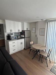 a kitchen with a table and chairs and a kitchen with white cabinets at Newly Renovated 1BR Suite, Patio BBQ, Fire Pit in Simi Valley
