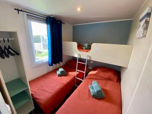 a small room with two bunk beds and a window at Mobilhome camping St jacques in Sarzeau +9 photos