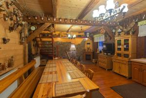 a dining room with a long table in a cabin at Sobiesz - Pokoje Gościnne in Jagniątków