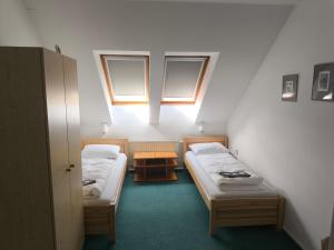 a small room with two beds and a window at Penzion-BelBar Zlín in Zlín