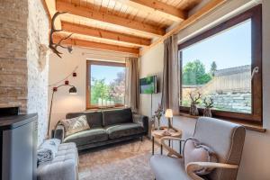 a living room with a couch and a large window at Stoderglück by Alpenidyll Apartments in Gröbming