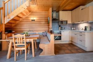 a kitchen with a dining table and a staircase at Stoderglück by Alpenidyll Apartments in Gröbming +12 photos