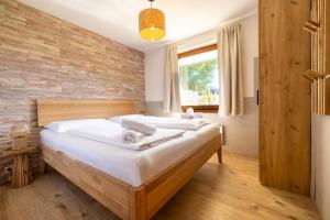 a bedroom with a bed and a brick wall at Stoderglück by Alpenidyll Apartments in Gröbming