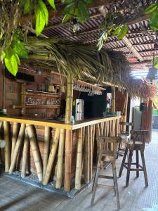 a bar with two chairs and a counter with bamboo at Casa Raizal in Envigado