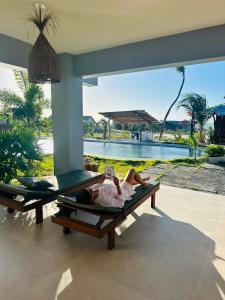 a woman laying on a bed in front of a pool at Casa da dunas in Prea