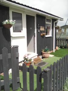 a black and white house with a fence at yeolde 2 bedroom Seashak Detached Cottage LOW 2026 PRICES NEWLY REFURBISHED PLUS FREE ALL ELECTRIC ENJOY in Bridlington