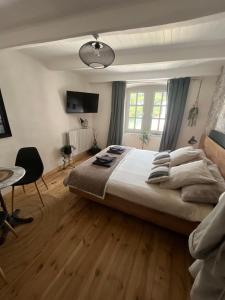 a bedroom with a large bed and a table at Le vieux colombier in Le Monastier sur Gazeille