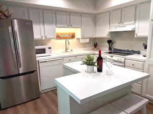 a kitchen with white cabinets and a stainless steel refrigerator at 767 Spinnaker Beach House in Seabrook Island