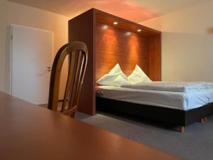 a bedroom with a bed with a wooden head board at Landhaus Hohenlohe in Rot am See