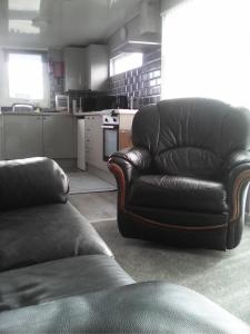 a living room with a leather chair and a couch at yeolde 2 bedroom Seashak Detached Cottage LOW 2026 PRICES NEWLY REFURBISHED PLUS FREE ALL ELECTRIC ENJOY in Bridlington