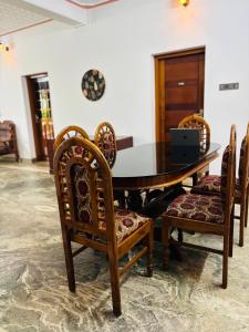 a dining room table with chairs and a laptop on it at Villa Lemon in Varkala +60 photos