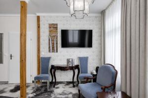 a living room with a table and chairs and a television at Monaco Ville Wellness in Międzyzdroje