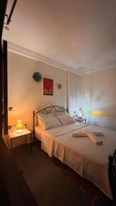 a bedroom with a bed and two tables with lamps at Moana Guest House in Tamraght Ouzdar