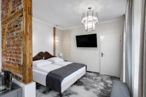 a bedroom with a bed and a tv on the wall at Monaco Ville Wellness in Międzyzdroje