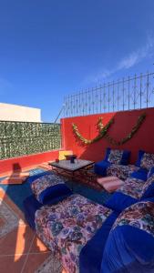 a room with many pillows and a table on a building at Moana Guest House in Tamraght Ouzdar