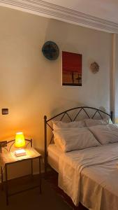 a bedroom with a bed and a table with a lamp at Moana Guest House in Tamraght Ouzdar +7 photos