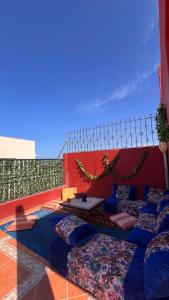 a patio with pillows and a table on a building at Moana Guest House in Tamraght Ouzdar