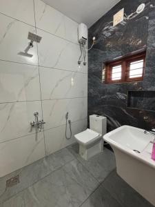 a bathroom with a toilet and a sink at Villa Lemon in Varkala