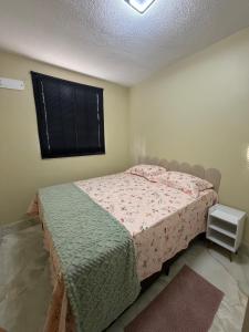 a small bedroom with a bed and a window at Apartamento Espaço e Conforto Cerejeiras in Várzea Grande