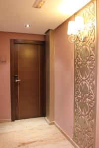 un corridoio con porta e lampadario a braccio di Hotel Venecia a Siviglia