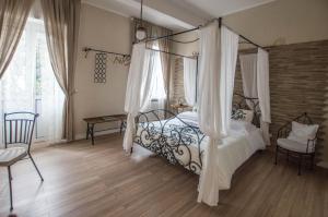 - une chambre avec un lit à baldaquin et une chaise dans l'établissement Leucos B&B, à Potenza