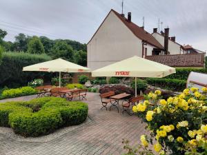 a patio with tables and umbrellas in a garden at Hotel Margo in Cedynia