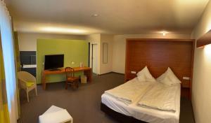 a bedroom with a bed and a desk with a computer at Landhaus Hohenlohe in Rot am See