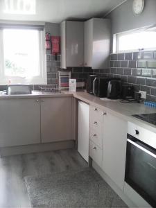 a small kitchen with white cabinets and a window at yeolde 2 bedroom Seashak Detached Cottage LOW 2026 PRICES NEWLY REFURBISHED PLUS FREE ALL ELECTRIC ENJOY in Bridlington