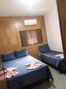 two beds in a room with pink clothes on them at LD Hotel in Três Lagoas