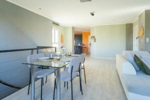 a dining room with a table and chairs and a couch at Duplex de Bandol - Plages et port à pied in Bandol