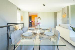 a dining room with a glass table and white chairs at Duplex de Bandol - Plages et port à pied in Bandol
