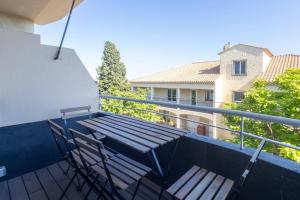 a wooden bench and two chairs on a balcony at Duplex de Bandol - Plages et port à pied in Bandol