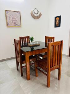a dining room table with three chairs and a table and a picture at Villa Lemon in Varkala