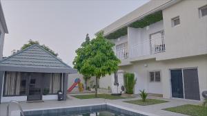 a house with a swimming pool in front of it at Family House Assinie in Assinie