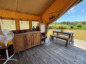 a tent with a kitchen and a table on a deck at Canvas chill-out in Ladignac-le-Long