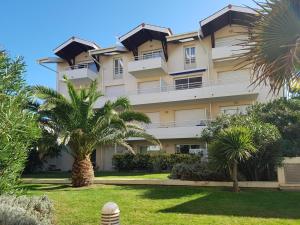 a building with palm trees in front of it at La croisière in Capbreton