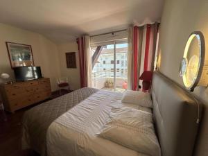 a bedroom with a large bed and a window at La croisière in Capbreton