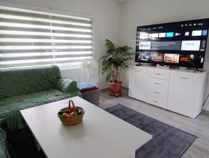 a living room with a couch and a table and a tv at Apartman Dzans in Jajce