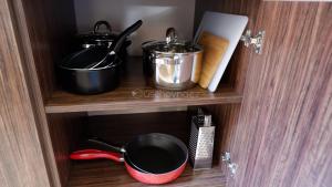a cupboard with pots and pans on a shelf at Apartmán Daniela in Bansko