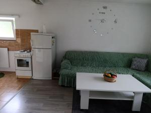 a living room with a green couch and a table at Apartman Dzans in Jajce