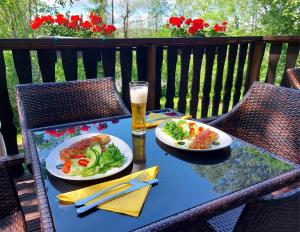 a table with two plates of food and a glass of beer at Cronin's Guesthouse Bed & Breakfast in Heinola