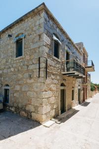 an old stone building with a balcony on the side at Mesta Grand Residence in Chios
