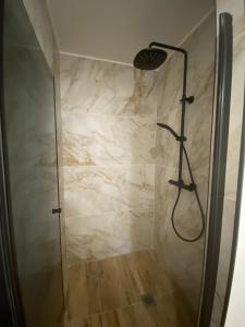 a bathroom with a shower with a marble wall at La Cabane Marine in Sangatte