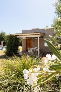 a house with a table and chairs in front of it at La Cañada Chascomús in Chascomús