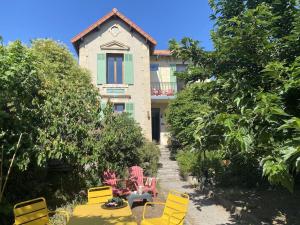 a house with yellow chairs and tables in front of it at QG Marseille in Marseille