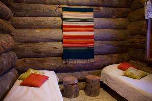 um quarto com duas camas num chalé de madeira em Osman Kelohovi em Utsjoki