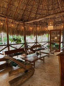 a group of tables in a straw hut at Hotel Boutique Cenote Secreto Maya in Valladolid +19 photos